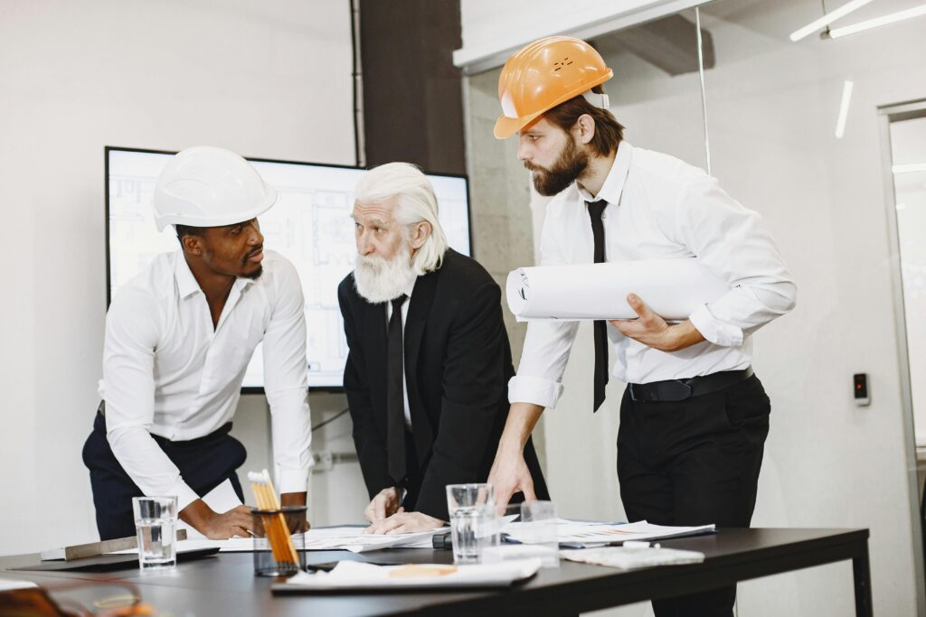 A diverse team of professionals discusses plans in an office environment.
